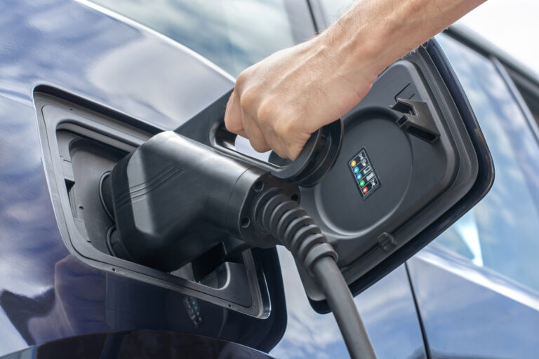 Human hand is holding electric car charging